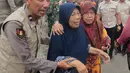 Sebanyak 102 santri korban ambruknya bangunan musala di Pondok Pesantren (Ponpes) Al Khoziny di Sidoarjo, Jawa Timur berhasil dievakuasi. Tampak dalam foto, petugas polisi membantu seorang perempuan berjalan keluar setelah bangunan runtuh di sebuah pesantren di Sidoarjo, Jawa Timur, Selasa 30 September 2025. (AP Photo/Trisnadi)