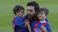 Lionel Messi bersama kedua putranya, Mateo dan Thiago. (AFP/Lluis Gene)
