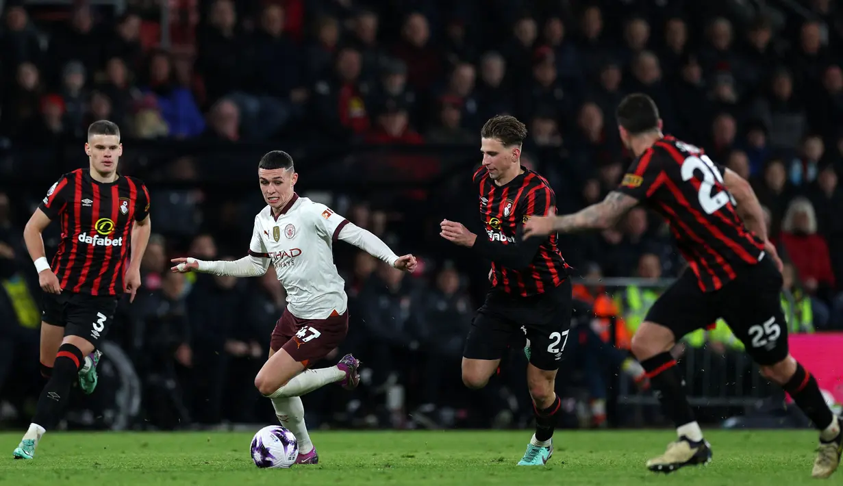 Pemain Manchester City, Phil Foden menggiring bola dibayangi sejumlah Bournemouth pada laga lanjutan Liga Inggris 2023/2024 yang berlangsung di Vitality Stadium, Bournemouth, Inggris, Minggu (25/02/2024) dini hari WIB. (AFP/Adrian Dennis)