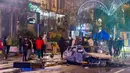 Orang-orang berdiri di samping mobil yang terbakar saat kerusuhan di Brussel, Belgia, 27 November 2022. Polisi harus menutup sebagian pusat Kota Brussel dan bergerak dengan meriam air serta gas air mata untuk membubarkan massa menyusul kerusuhan selama dan setelah Maroko menang 2-0 atas Belgia di Piala Dunia 2022. (AP Photo/Geert Vanden Wijngaert)