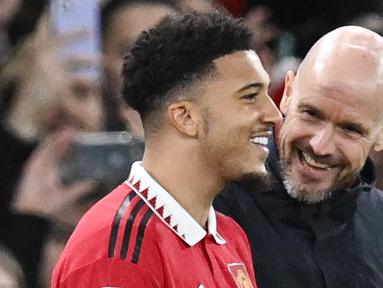 Pemain Manchester United, Jadon Sancho, tersenyum saat akan dimasukkan Erik ten Hag melawan Nottingham Forest pada leg kedua babak semifinal Carabao Cup, Stadion Old Trafford, Jumat (2/2/2023). Setelah cukup lama hilang, Sancho muncul di skuad United pada duel lawan Nottingham. Pada menit ke-63, Sancho dimainkan untuk menggantikan Antony. (AFP/Paul Ellis)
