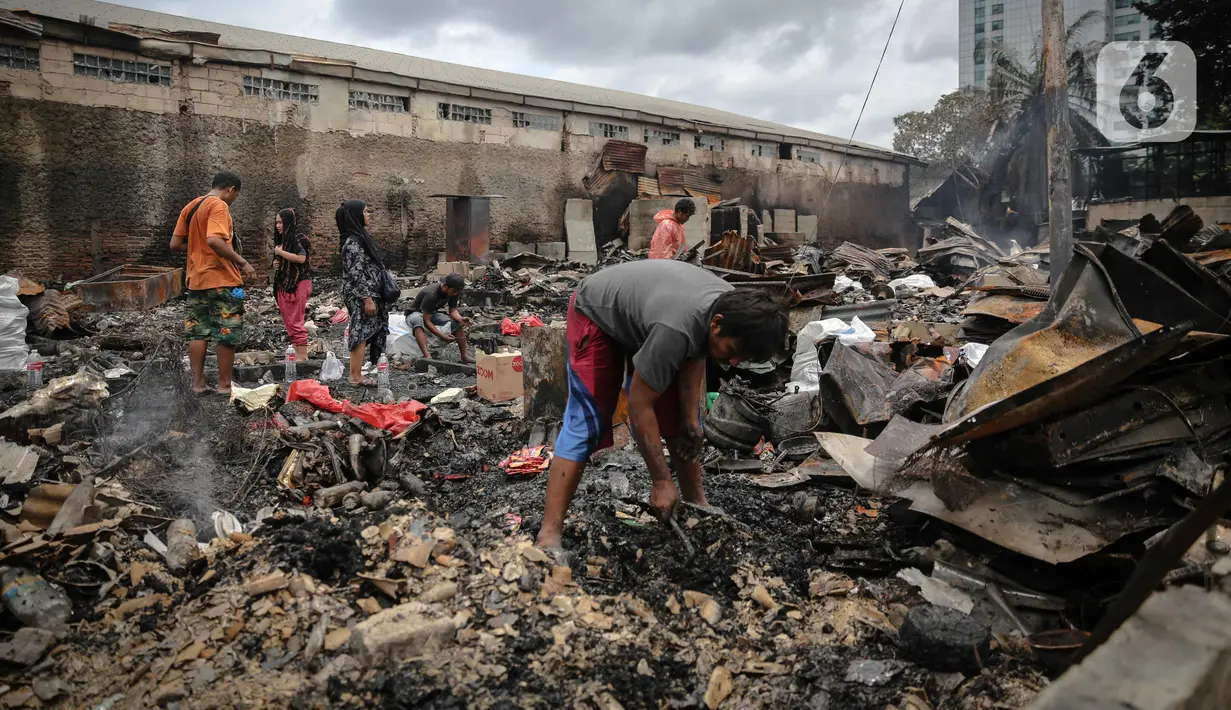 Warga mencari barang berharga di sekitar puing-puing bangunan tempat tinggal mereka yang terbakar di Jalan Tanah Abang 5 RT 003,004/RW 003, Petojo Selatan, Gambir, Jakarta Pusat, Senin (27/2/2023). Adapun situasi dan status kebakaran pada pukul 21.47 WIB, Minggu 26 Februari 2023 dalam proses pendinginan (kuning) yang telah berlangsung sejak 21.20 WIB. (Liputan6.com/Faizal Fanani)