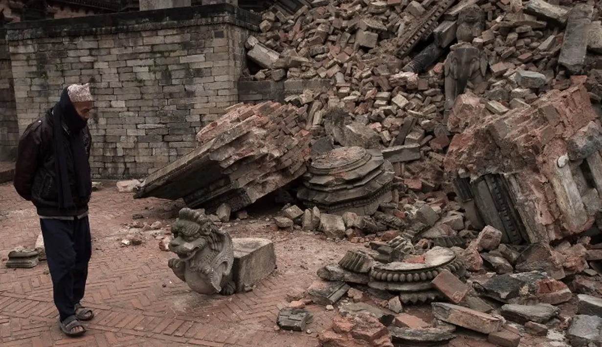Seorang laki-laki melihat sisa bangunan yang runtuh akibat gempa berkekuatan 7,8  di sekitar Kathmandu, Nepal  (30/4/2015). Gempa berkekuatan 7,8 yang meluluhlantakkan Nepal pada 25 April 2015 lalu. (Nicolas Asfouri/AFP)