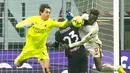 Kiper AC Milan Ciprian Tatarusanu meninju bola di bawah tekanan dari pemain AS Roma Tammy Abraham (kanan) pada pertandingan sepak bola Serie A Liga Italia di Stadion San Siro, Milan, Italia, 8 Januari 2023. Pertandingan berakhir imbang 2-2. (AP Photo/Antonio Calanni)