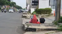 Salah satu pengemis bersama anaknya di Jalan Raya Margonda, Kota Depok, Jawa Barat, Minggu (18/4/2021). (Liputan6.com/Dicky Agung Prihanto)