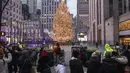 Orang-orang berfoto dengan latar belakang pohon Natal di viewing zone pohon Natal Rockefeller Center di New York, Amerika Serikat (AS) (22/12/2020). Jumlah kasus COVID-19 di negara itu naik menjadi 18.006.061, dengan total 319.190 kematian, hingga Selasa (22/12) pukul 06.22 WIB. (Xinhua/Wang Ying)