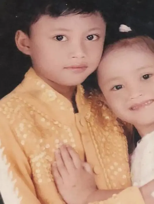 Penyanyi kelahiran 25 Februari 1998 ini saat kecil memang sudah terlihat berparas tampan. Kakak Putri Delina ini tampil begitu kalem dengan balutan pakaian muslim warna krem. Penampilan kalem Iky saat kecil ini tuai atensi publik. (Liputan6.com/IG/rizkyfbian)
