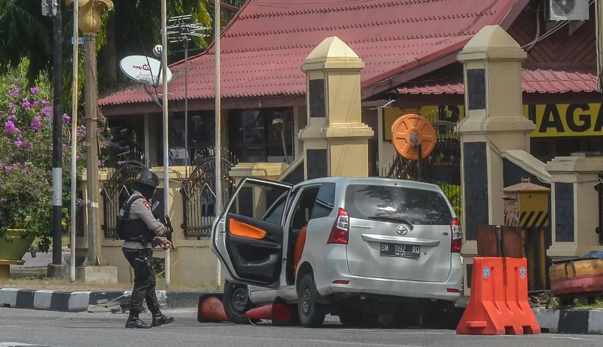 Petugas kepolisian mengamankan mobil yang digunakan terduga teroris setelah serangan di luar markas polisi di Pekanbaru, Riau (16/5). Empat pelaku penyerangan ditembak dan tewas ketika mereka melakukan serangan.  (AFP Photo/Dedy Sutisna)
