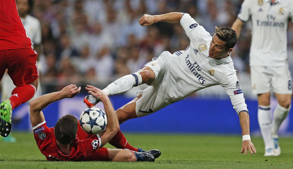 Aksi Cristiano Ronaldo saat berebut bola dengan pemain Bayern Munchen, Xabi Alonso pada leg kedua perempatfinal Liga Champions di Santiago Bernabeu stadium, Madrid, (18/4/2017). Real Madrid menang 4-2. (AP/Francisco Seco)