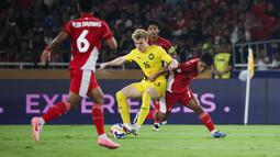 Pemain Timnas Indonesia U-23, Toni Firmansyah (kanan) berebut bola dengan pemain Malaysia, Fergus Tierney dalam laga Grup A Piala AFF U-23 2025 di Stadion Utama Gelora Bung Karno (SUGBK), Senayan, Jakarta, Senin (21/07/2025). (Bola.com/Abdul Aziz)