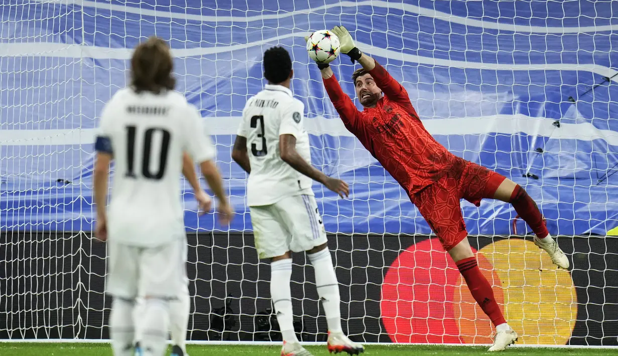 <p>Penjaga gawang Real Madrid, Thibaut Courtois berusaha menangkap bola saat bertanding melawan Celtic pada pertandingan Grup F Liga Champions di stadion Santiago Bernabeu di Madrid, Spanyol, Kamis (3/11/2022). Real Madrid menang telak atas Celtic dengan skor 5-1. (AP Photo/Manu Fernandez)</p>