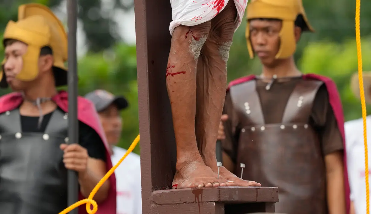 Selama penyaliban yang realistis ini, para aktor menancapkan paku ke kedua tangan dan kakinya, lalu mengangkatnya di atas kayu salib. (AP Photo/Aaron Favila)