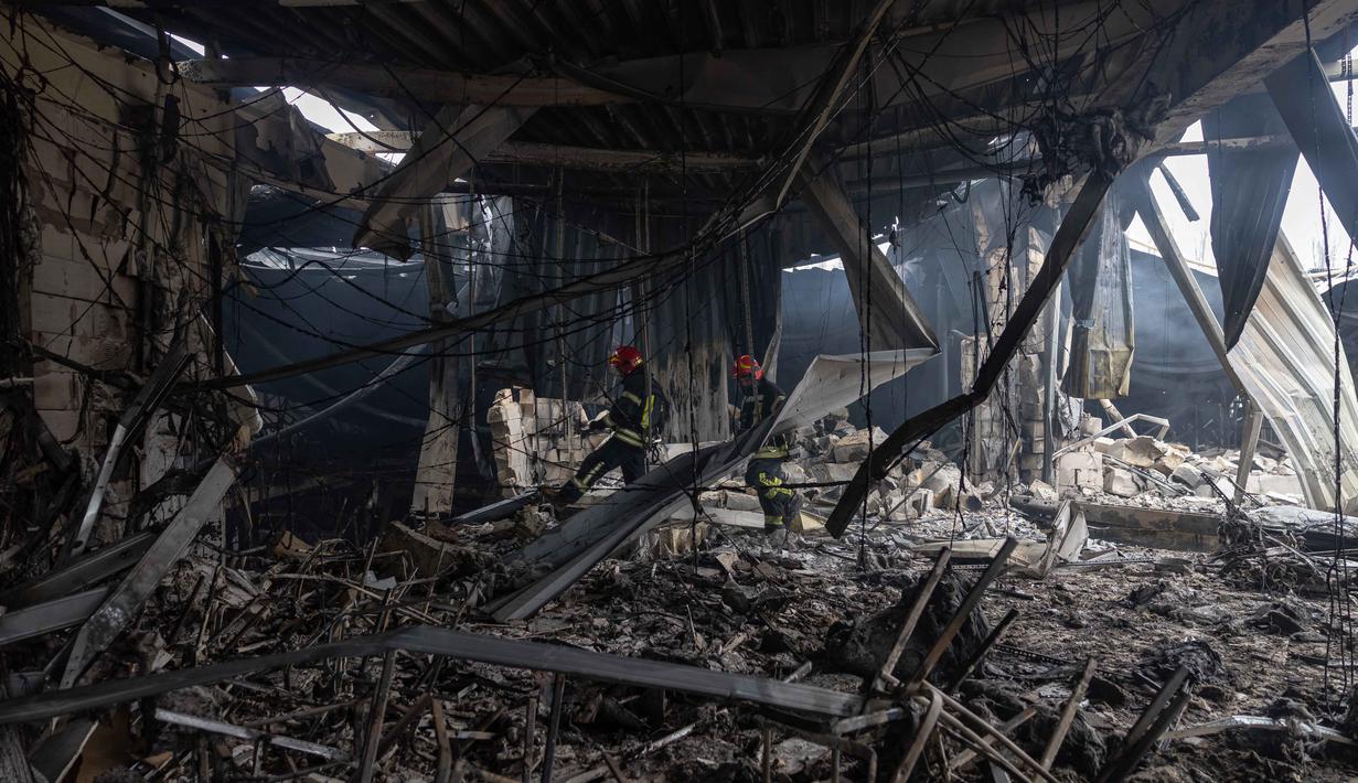 Para petugas penyelamat dari Layanan Darurat Negara Ukraina berjalan melewati reruntuhan bangunan yang rusak parah di Odesa pada Jumat 13 Februari 2026. Gelombang serangan udara besar-besaran Rusia kembali menghantam sejumlah wilayah di Ukraina pada Kamis 12 Februari 2026. (Oleksandr GIMANOV/AFP)