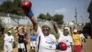 Para nenek pemanasan sebelum latihan tinju pada Boxing Gogos di Cosmo City, Johannesburg, Selasa (19/9/2017). Berkat latihan rutin yang dipimpin Claude Maphosa ini para lansia berhasil sembuh dari penyakit dan hidup lebih sehat. (AFP/Gulshan Khan) 