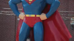 Warga berpose di bawah patung Superman di Metropolis, Illinois (18/8). Pada 21 Agustus mendatang, gerhana matahari total akan terlihat jelas di AS, tepatnya di pantai South Carolina sampai Oregon. (Scott Olson / Getty Images / AFP)