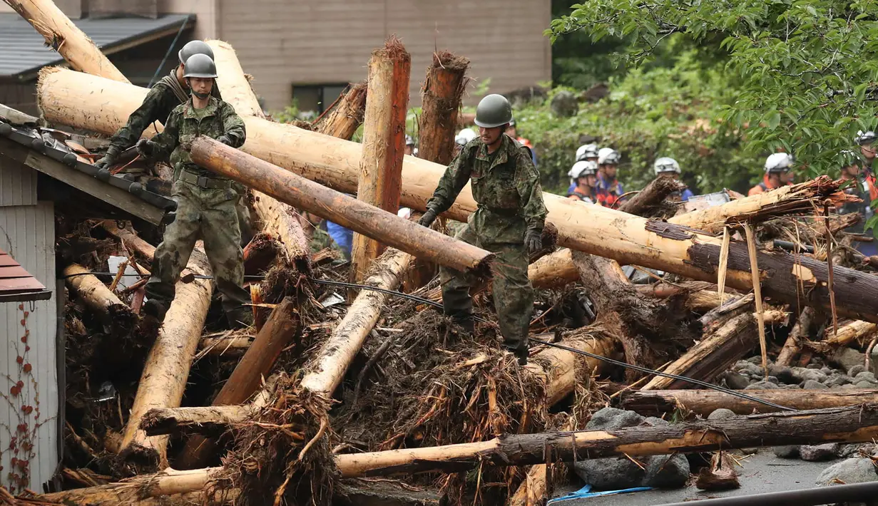 Petugas penyelamat melakukan operasi pencarian untuk orang hilang di Toho, prefektur Fukuoka, Jepang, Sabtu (8/7).  Banjir di barat daya Jepang tersebut telah mengisolasi sejumlah warga akibat akses jalan yang tertutup puing. (AFP PHOTO / JIJI PRESS)