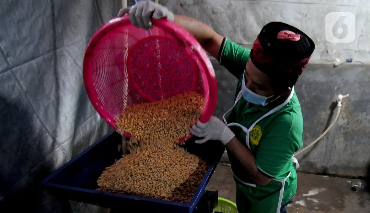 Seorang santri menyelesaikan pembuatan tempe di Pondok Pesantren Sirajussa'adah, Depok, Jawa Barat, Selasa (23/3/3021). Tempe Santri dijual dengan harga Rp 6.000 per bungkus. (merdeka.com/Arie Basuki)