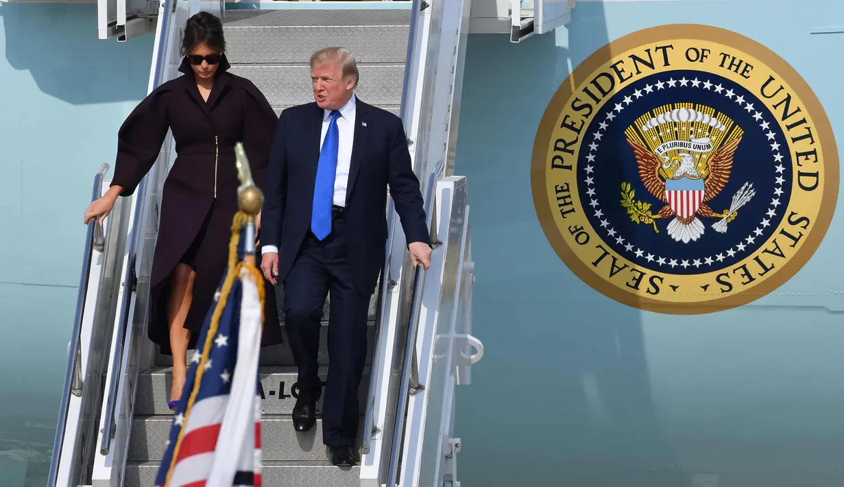 Presiden AS Donald Trump bersama istrinya Ibu Negara Melania saat menuruni tangga pesawat saat tiba di Pangkalan Udara Osan, Pyeongtaek, Korea Selatan, (7/11). (AFP Photo/Song Kyung-Seok)