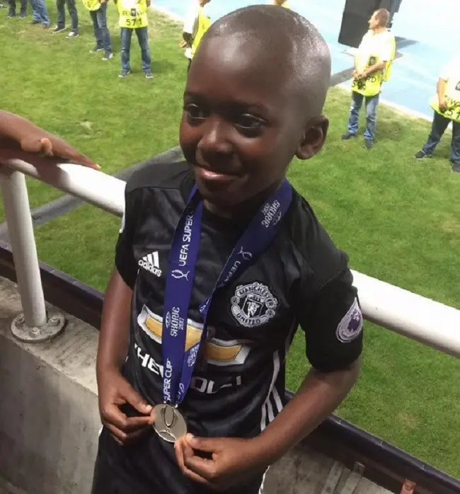 Pendukung bocah Manchester United (MU), Adedeji Odumboni, memamerkan medali runner-up Piala Super Eropa 2017 yang diterimanya dari Jose Mourinho. (Twitter)