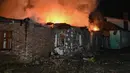 Hingga Senin (24/11/2025), perang Rusia–Ukraina telah memasuki hari ke-1.370. Tampak dalam foto, kebakaran menghanguskan sebuah rumah yang hancur akibat serangan pesawat nirawak Rusia di Kharkiv pada Minggu 23 November 2025, di tengah invasi Rusia ke Ukraina. (SERGEY BOBOK/AFP)