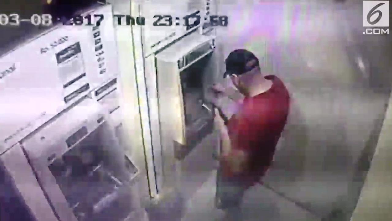 CCTV merekam aksi anggota sindikat kejahatan siber internasional memasang alat skimming di sebuah ATM di Surabaya, Jawa Timur