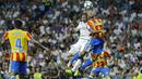 Pemain Real Madrid, Karim Benzema (kiri) atas) menyundul bola saat duel dengan pemain Valencia, Ruben Vezo pada lanjutan La Liga Spanyol di Santiago Bernabeu stadium, Madrid, (27/8/2017). Real ditahan Imbang 2-2. (AP/Francisco Seco)