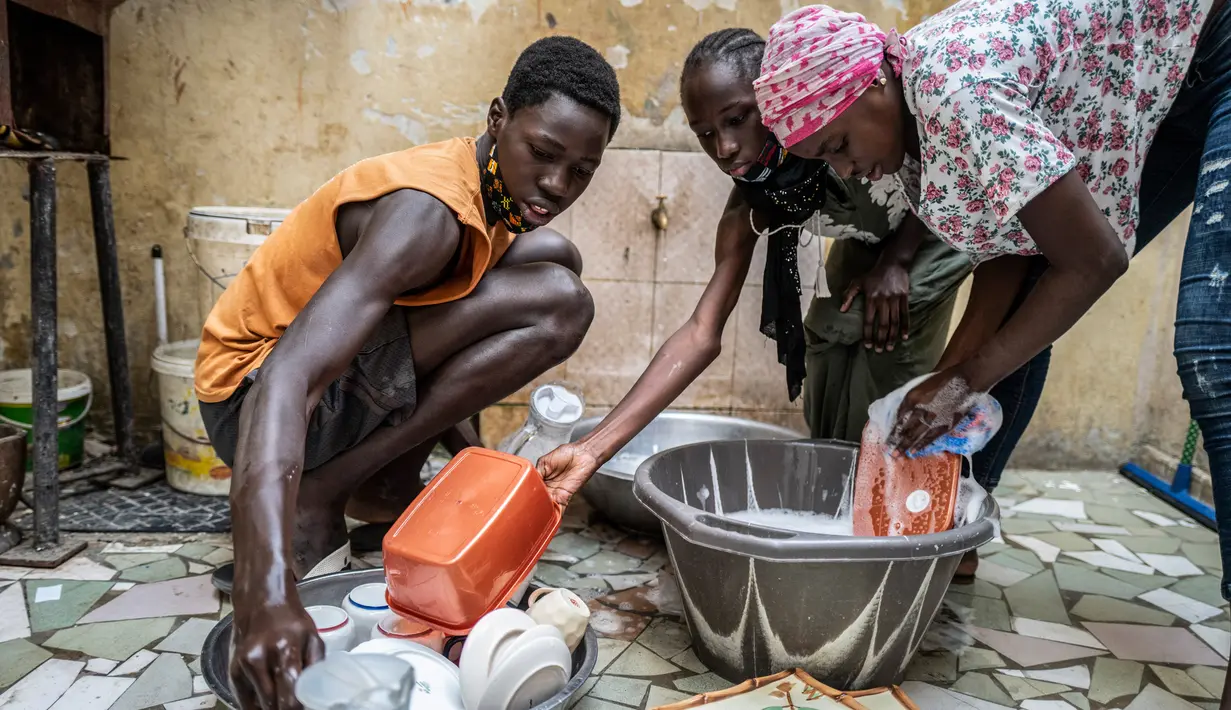 Anak-anak Bara Tambedou mencuci piring sebelum berbuka puasa pada bulan suci Ramadan, di Dakar, Senegal, 25 April 2020. Tahun ini, banyak keluarga menjalankan Ramadan di rumah dengan larangan pertemuan publik dan penerapan jam malam untuk menekan penyebaran Covid-19. (AP/Sylvain Cherkaoui)