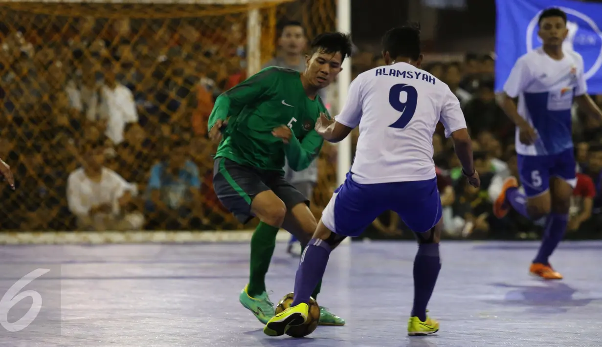 Pemain Timnas Futsal Indonesia mencoba menahan pergerakan pemain IPC Pelindo II saat laga uji coba di Jakarta, Minggu (15/1). Timnas Futsal Indonesia akan melakoni laga piala AFF 2017, akhir Januari. (Liputan6.com/Helmi Fithriansyah)