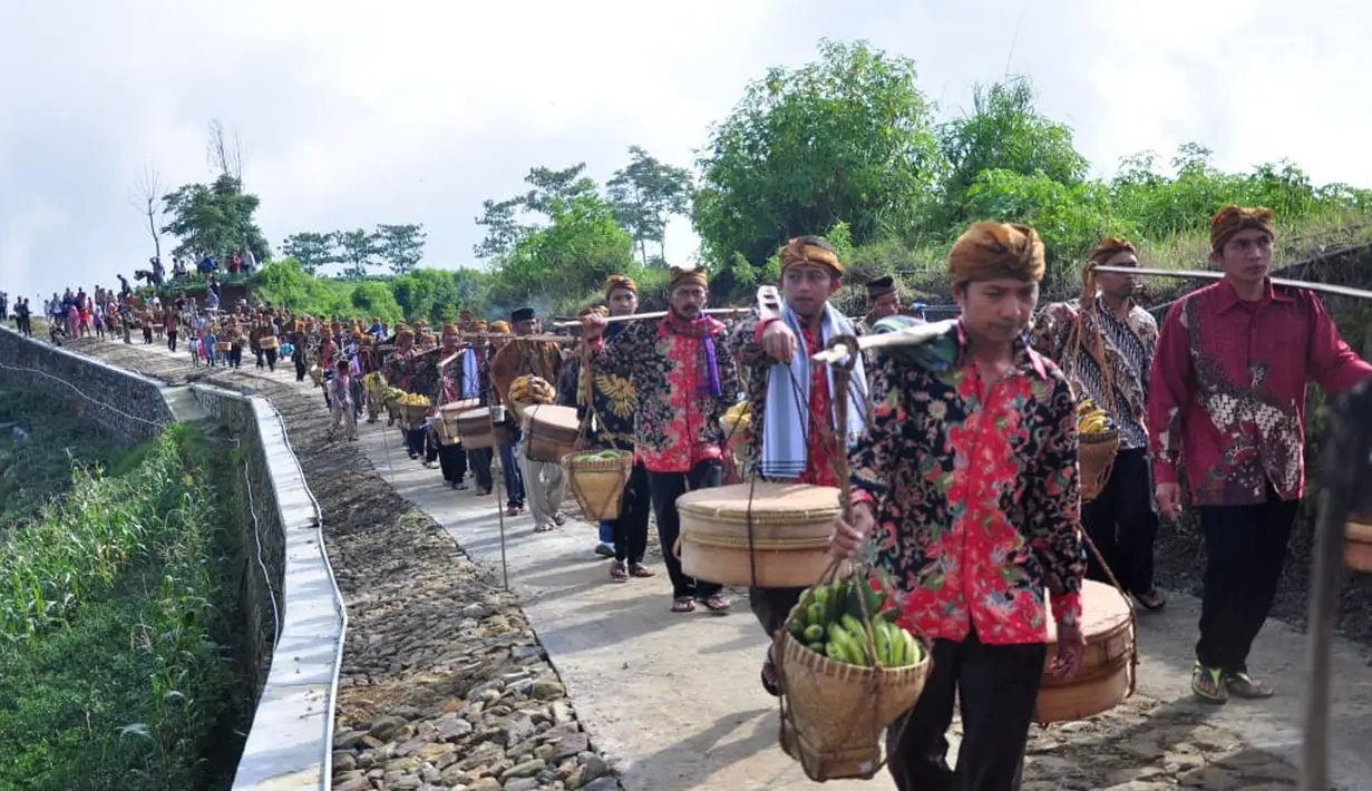 Warga membawa tenongan menuju makam sesepuh mereka saat mengikuti Sadranan Rejeban Plabengan di Lereng Gunung Sumbing, Temanggung, Jawa Tengah, Jumat (22/3). Dalam tradisi ini warga menggelar doa dan makan bersama di makam sesepuh. (Liputan6.com/Gholib)