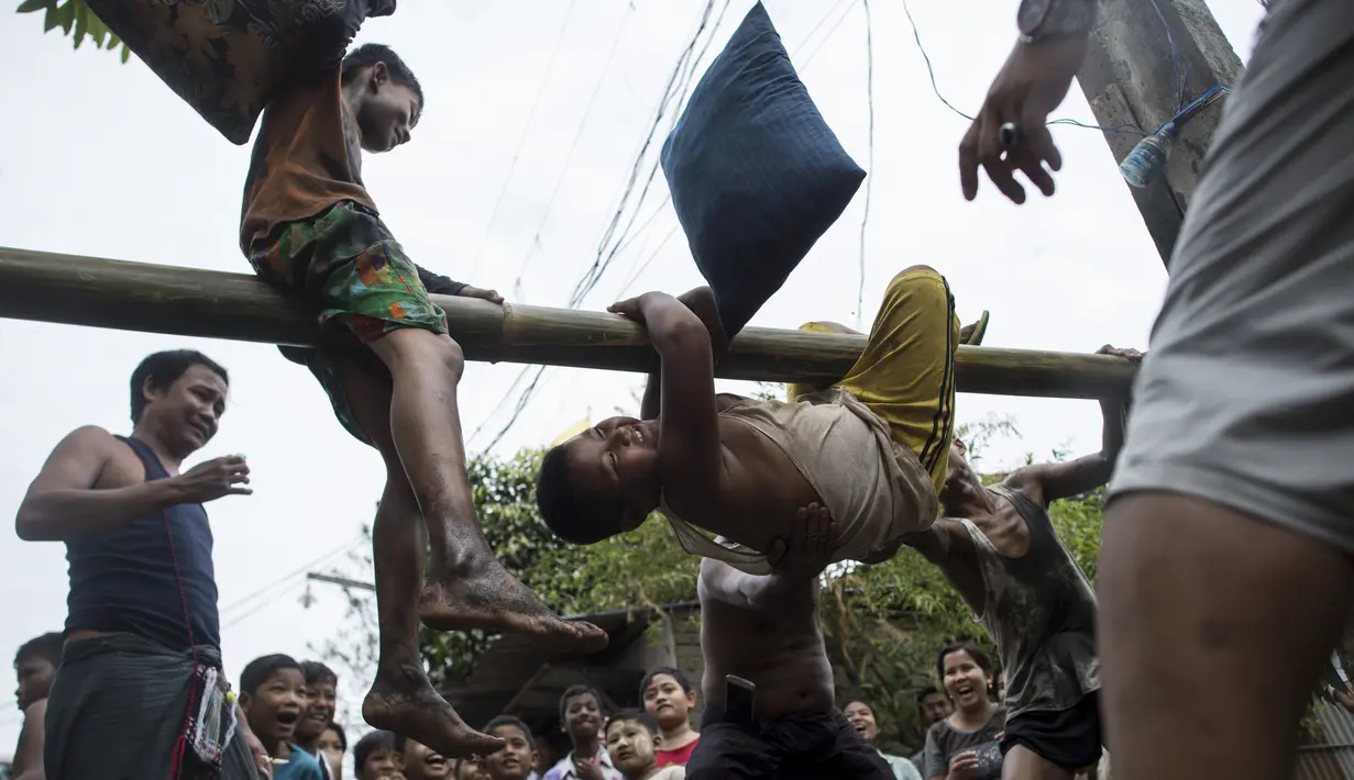 Seorang anak nyaris terjatuh saat mengikuti Perang Bantal di Yangon, Rabu (4/1). Acara tersebut digelar dalam rangka HUT Kemerdekaan Myanmar ke-69. (AFP PHOTO / YE AUNG THU)
