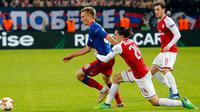 Pemain CSKA Moscow, Konstantin Kuchaev berebut  bola dengan pemain Arsenal, Hector Bellerin pada laga leg kedua perempat final Liga Europa di VEB Arena, Jumat (13/4). Berkat hasil imbang 2-2 , Arsenal unggul dengan agregat 6-3. (AP/Pavel Golovkin)