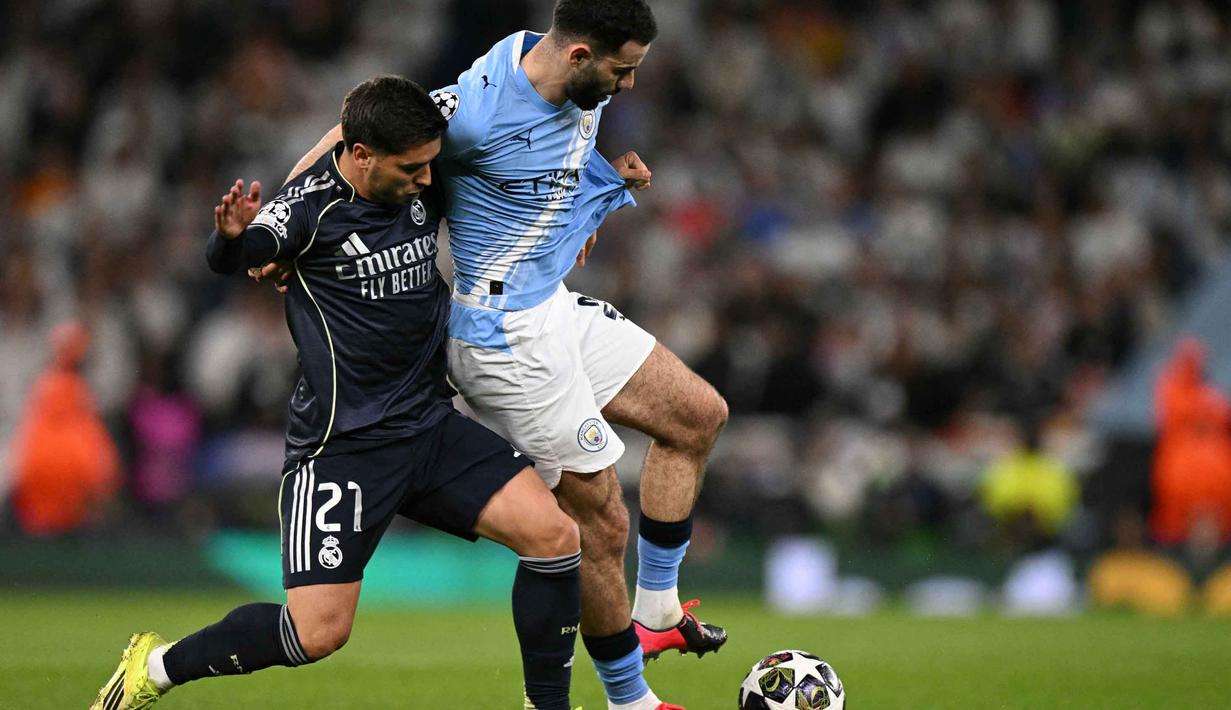 Beberapa kali, skema serangan yang dibangun The Citizens mampu merepotkan barisan pertahanan Real Madrid. Tampak dalam foto, penyerang Real Madrid asal Maroko, Brahim Diaz (kiri), berduel dengan bek Manchester City asal Aljazair, Rayan Ait-Nouri, saat pertandingan leg kedua 16 besar Liga Champions 2025/2026 di Etihad Stadium, barat laut Inggris, pada Selasa 17 Maret 2026 waktu setempat atau Rabu (18/3) dini hari WIB. (Oli SCARFF/AFP)