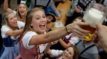 Seorang wanita mengambil gelas bir selama pembukaan festival bir Oktoberfest di 184, Munich, Jerman, (16/9). Festival ini diadakan dari tanggal 16 sampai 3 Oktober 2017. (AP Photo / Matthias Schrader)