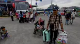 Peserta mudik gratis berjalan menuju bus di Terminal Pondok Cabe, Tangerang Selatan, Banten, Kamis (27/3/2025). (merdeka.com/Arie Basuki)
