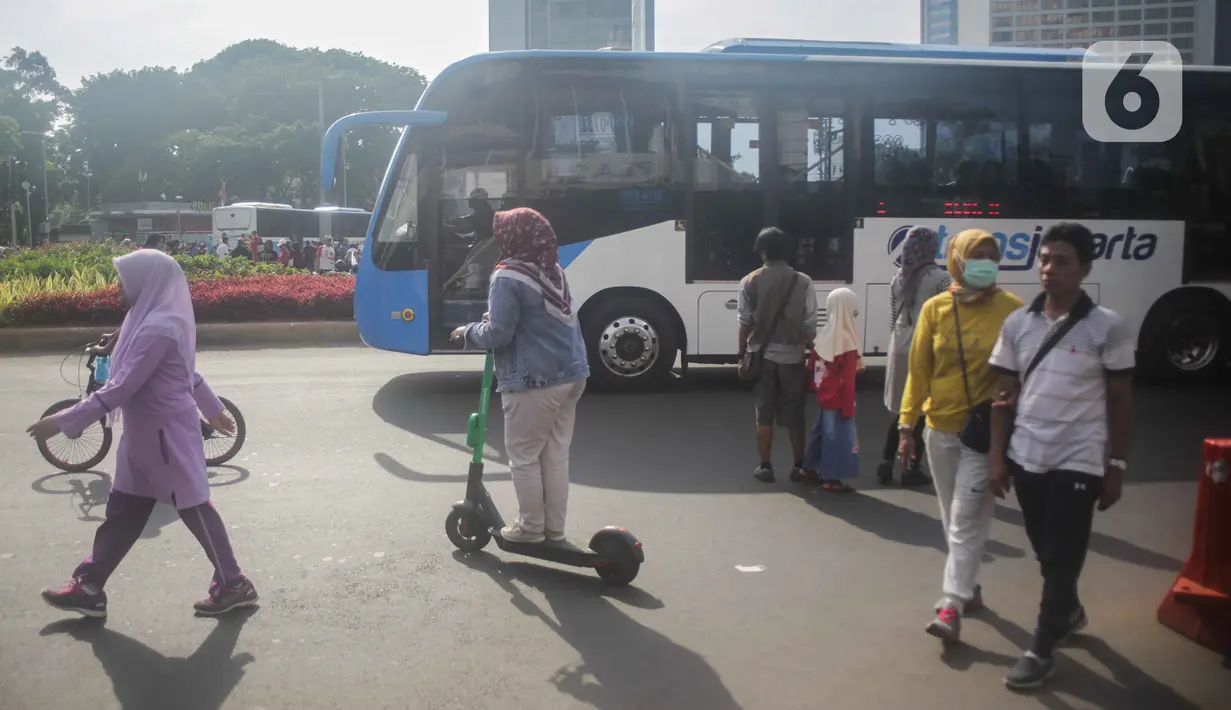 Warga mengendarai skuter listrik saat Car Free Day (CFD) di kawasan Bundaran HI, Jakarta, Minggu (17/11/2019). Dinas Perhubungan DKI Jakarta melarang penggunaan skuter listrik di kawasan CFD. (Liputan6.com/Faizal Fanani)