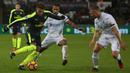 Gelandang Arsenal, Alex Oxlade-Chamberlain, berusaha melewati hadangan pemain Swansea. Meski bermain tandang, The Gunners sudah tampil menyerang sejak babak pertama baru dimulai. (AFP/Geoff Caddick)