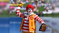 Ronald McDonald bersiap melempar bola saat latihan musim semi bisbol sebelum pertandingan Minggu antara Royals Kansas City dan Los Angeles Dodgers di Surprise, Arizona. (John Sleezer/The Kansas City Star via AP)