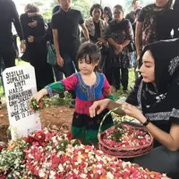 Tyas Mirasih menaburkan bunga di makam kakak sepupunya (Instagram/@tyasmirasih)