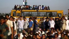 Sejumlah orang duduk di bus sekolah saat memblokir jalan dalam demonstrasi di negara bagian Haryana ke New Delhi, India,Minggu (21/2). Demonstrasi dan aksi kekerasan akibat kelangkaan air di wilayah tersebut menewaskan 10 orang. (REUTERS/Adnan Abidi)