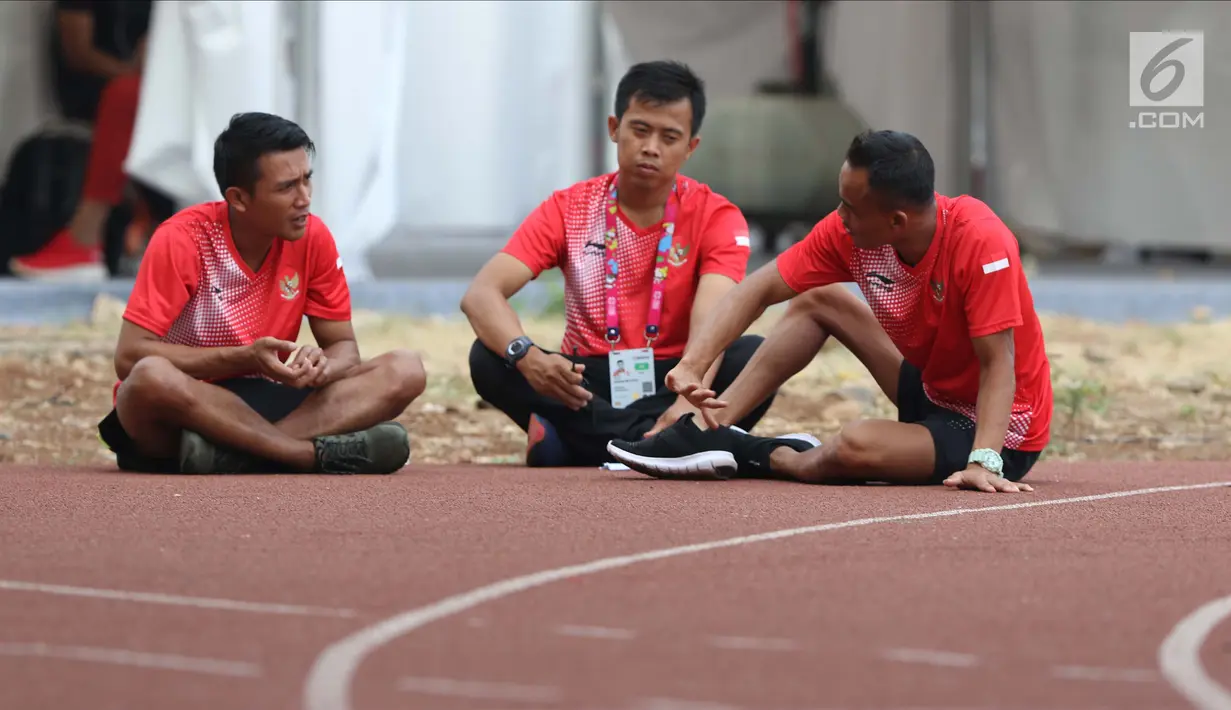 Atlet Para Atletik Indonesia, Mulyono (kanan) duduk berbincang dengan timnya di Stadion Madya Kompleks Gelora Bung Karno, Jakarta, Kamis (11/10). Berbagai aktivitas dilakukan para atlet para atletik di luar arena. (Liputan6.com/Helmi Fithriansyah)