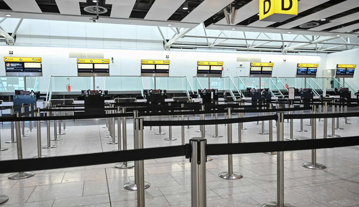 Penutupan ini imbas serangan yang diluncurkan Amerika Serikat dan Israel terhadap Iran pada Sabtu (28/2/2026) pagi. Tampak dalam foto, meja-meja kosong terlihat di konter check-in maskapai penerbangan Etihad di Bandara Heathrow, London pada Minggu 1 Maret 2026. (JUSTIN TALLIS/AFP)