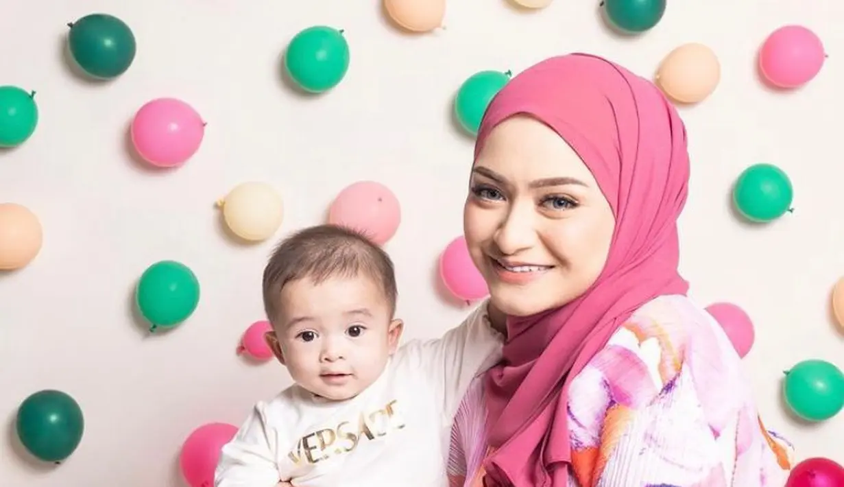 3. Seperti inilah gaya pemotretan Nathalie dan sang buah hati. Perempuan 29 tahun ini tampil ala cewek kue mengenakan pleats dress colorful dan hijab warna pink fuschia. (Instagram/nathalieholscher).