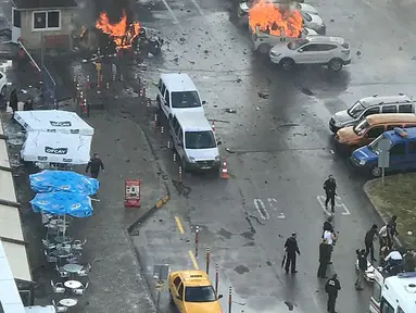 Sejumlah mobil terbakar setelah ledakan terjadi di luar sebuah pengadilan di kota Izmir, wilayah barat Turki, Kamis (5/1). Sedikitnya 10 orang terluka akibat kejadian ini. (DHA/Dogan News Agency/AFP)
