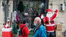 Orang-orang berjalan melewati dekorasi Sinterklas yang dipajang di luar sebuah toko di Kota Tua Yerusalem (7/12/2020). (Xinhua/Muammar Awad)