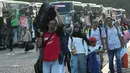 Program bertajuk "Aman Nyaman Bawa Cerita Bahagia" ini menggunakan 709 bus ke 20 kota/kabupaten tujuan. Tampak dalam foto, orang-orang membawa barang-barang mereka saat tiba untuk perjalanan mudik gratis yang diselenggarakan oleh Pemerintah Provinsi Jakarta di Lapangan Monumen Nasional, Selasa 17 Maret 2026. (AP Photo/Achmad Ibrahim)