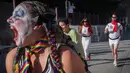Peserta berdandan seperti badut berlarian selama acara parodi tahunan "Running of the Clowns" di Pasadena, California pada 20 Oktober 2019. Lari dikejar kawanan badut ini merupakan parodi yang mengolok-olok lomba dikejar banteng di Spanyol. (Mark RALSTON / AFP)
