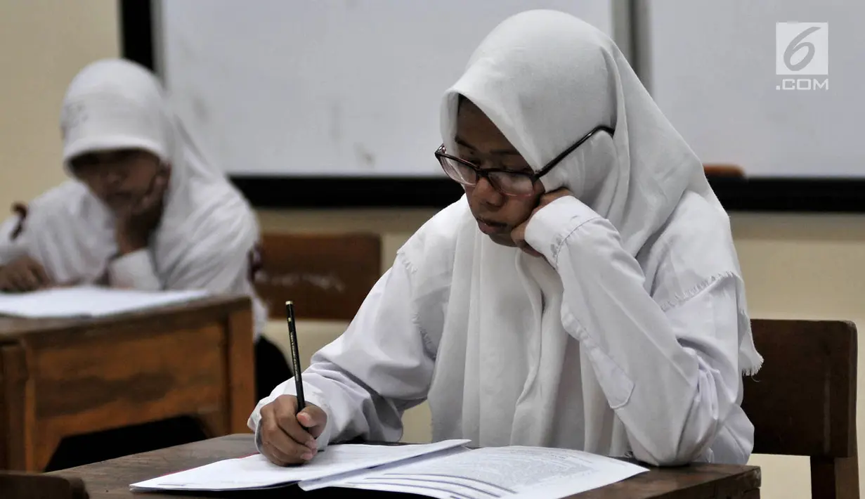 Siswa Sekolah Menengah Pertama Luar Biasa (SMPLB) Kategori B atau tunarungu saat mengerjakan Ujian Nasional Kertas Pensil (UNKP) di SLB Negeri 7 Jakarta, Selasa (24/4). Lima di antara peserta merupakan siswa SLB Negeri 7. (Merdeka.com/Iqbal Nugroho)