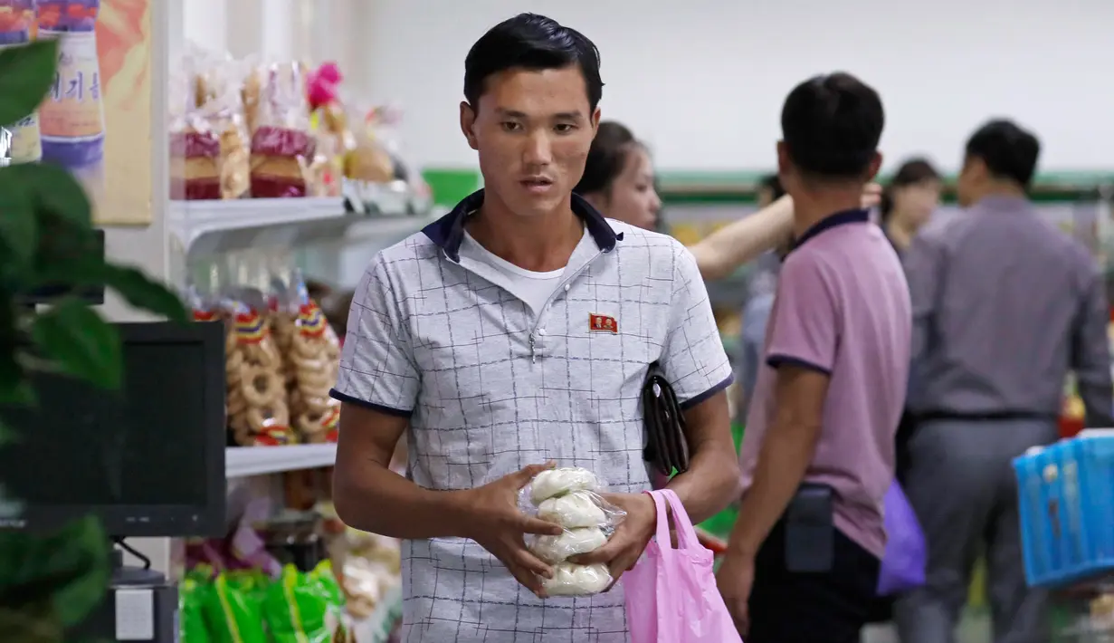 Seorang pria berbelanja di supermarket di Pyongyang, Korea Utara (12/9). Banyak produk dalam negeri terlihat di rak-rak supermarket tersebut sebagai bagian dari upaya membangun ekonominya dan meningkatkan standar hidup nasional. (AP Photo/Kin Cheung)