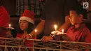 Dua anak memegang lilin pada Misa Natal di Gereja Protestan Indonesia Barat (GPIB) Immanuel, Gambir, Jakarta, Minggu (24/12). Misa Natal 2017 mengusung tema Damai Sejahtera. (Liputan6.com/Herman Zakharia)