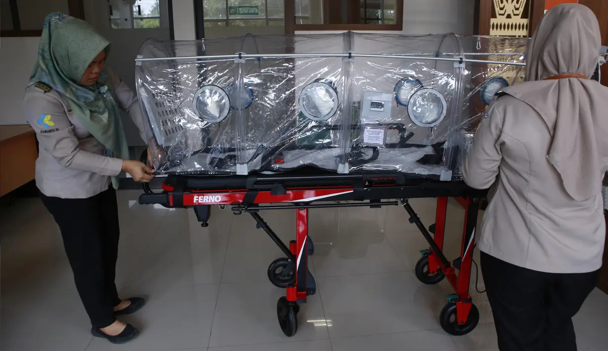 Petugas kesehatan Pelabuhan Kelas II Panjang membawa tandu pelindung (isolation camber) di Lampung, Selasa (28/1/2020). Kantor Kesehatan Pelabuhan (KKP) Kelas II Panjang menyiapkan satu unit isolation camber untung menangkal virus corona dari Wuhan, China. (AFP/Perdiansyah)